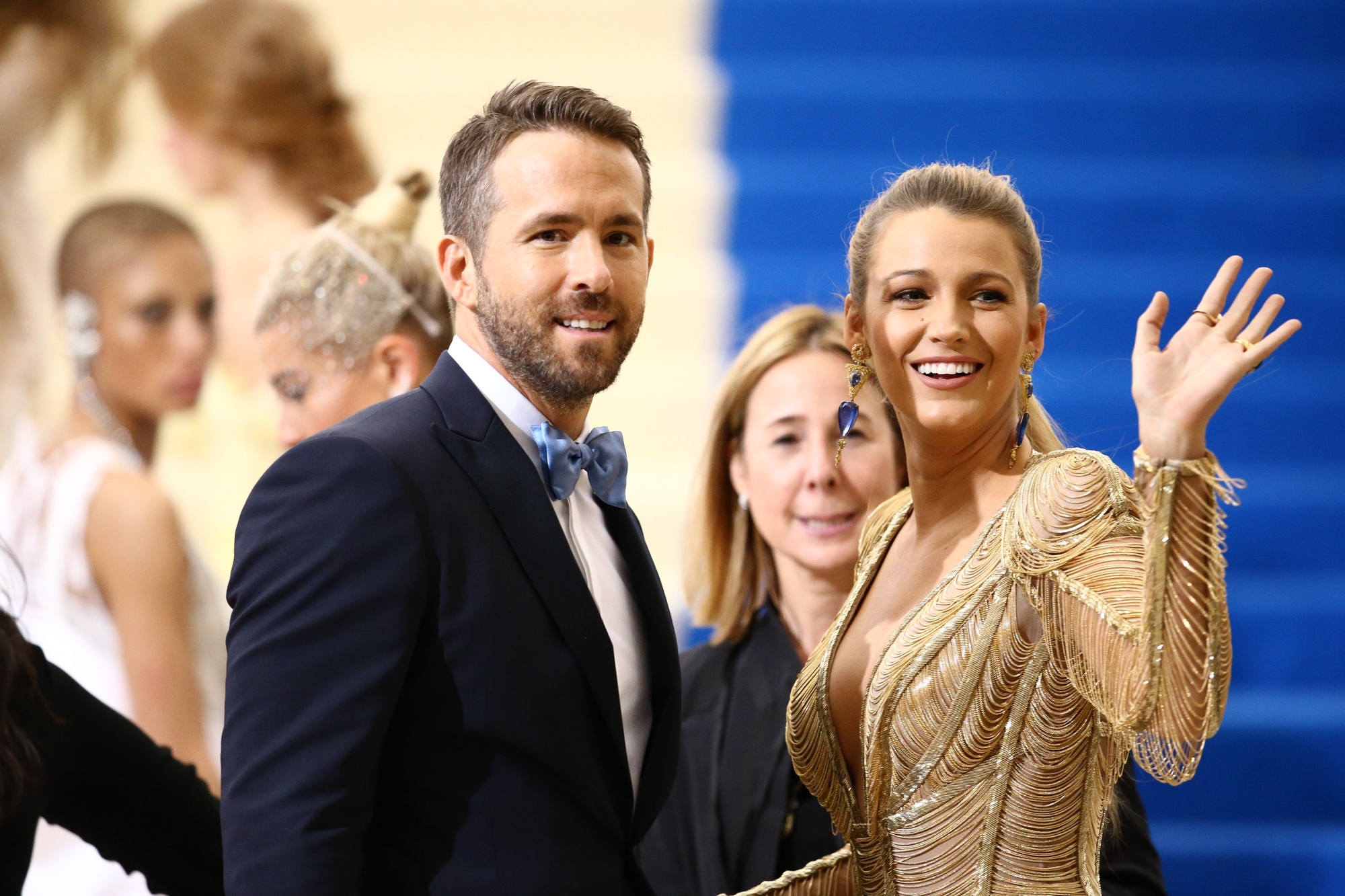 Blake Lively and Ryan Reynolds in a gold dress and tuxedo at an event. Photo via everett225