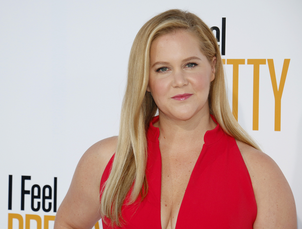 Amy Schumer in a red gown at a premiere for I Feel Pretty