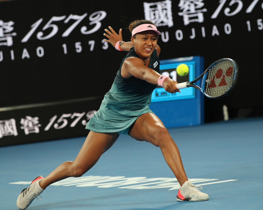 Naomi Osaka in the middle of a return while playing tennis