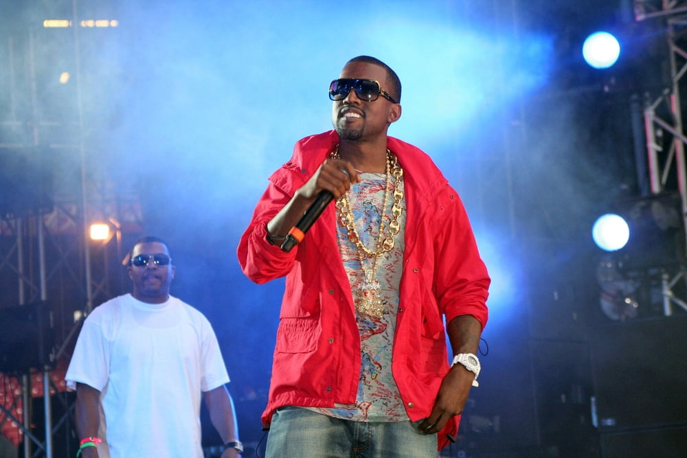 Kanye west performing in sunglasses and a red jacket. Photo by everett225