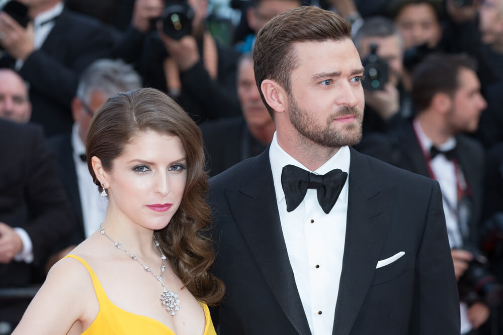 Anna Kendrick wearing a yellow dress and silver necklace with matching earrings on red carpet with Justin Timberlake. Photo by Deposit Photos user magicinfoto