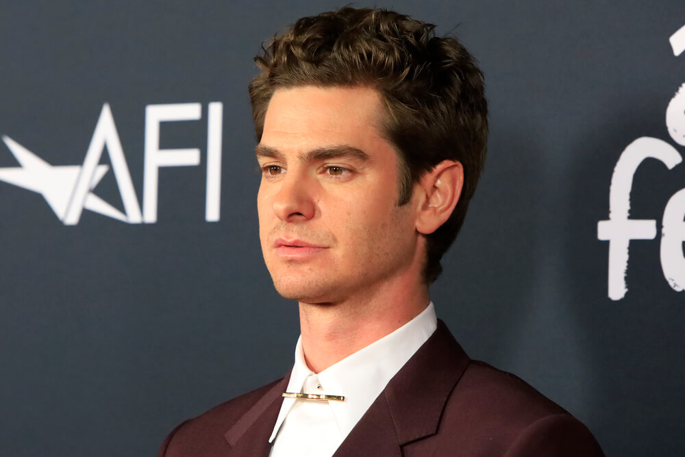 Andrew Garfield wearing white button-down shirt with gold tie clip under black suit at AFI fest red carpet. Photo by Deposit Photos user Jean_Nelson
